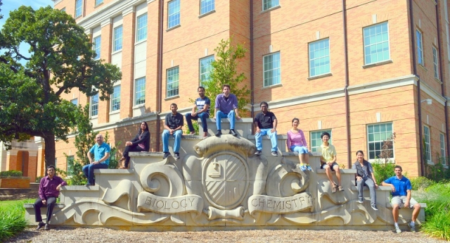 Bioinformatics team posing for a photo on the Biology and Chemistry monument on campus