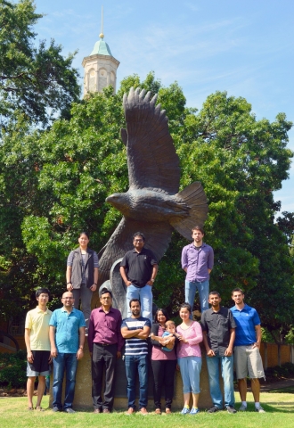 Bioinformatics team standing in front of the eagle statue on campus